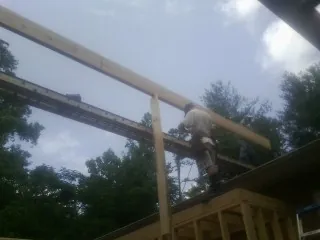 Carpenter setting a ridge beam over a new addition frame — Ice Dam Removal by Roofing Brothers in Sugar Tree