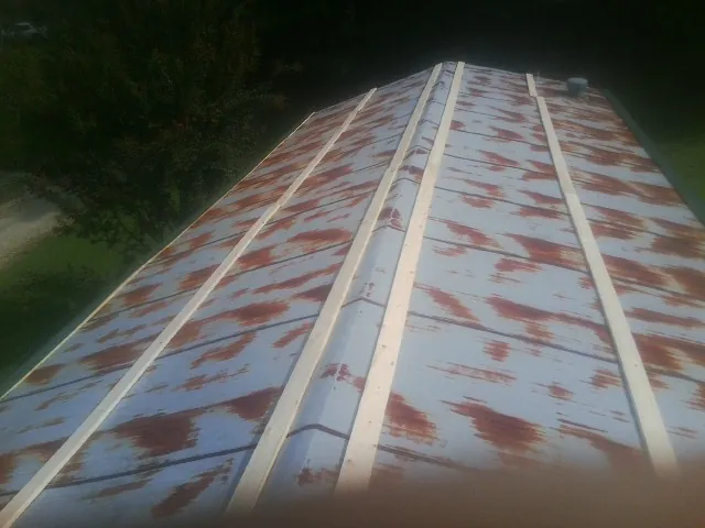 Rusted metal roof panels with new wood purlins before replacement — Storm Damage Roof Repair in Sugar Tree by Roofing Brothers