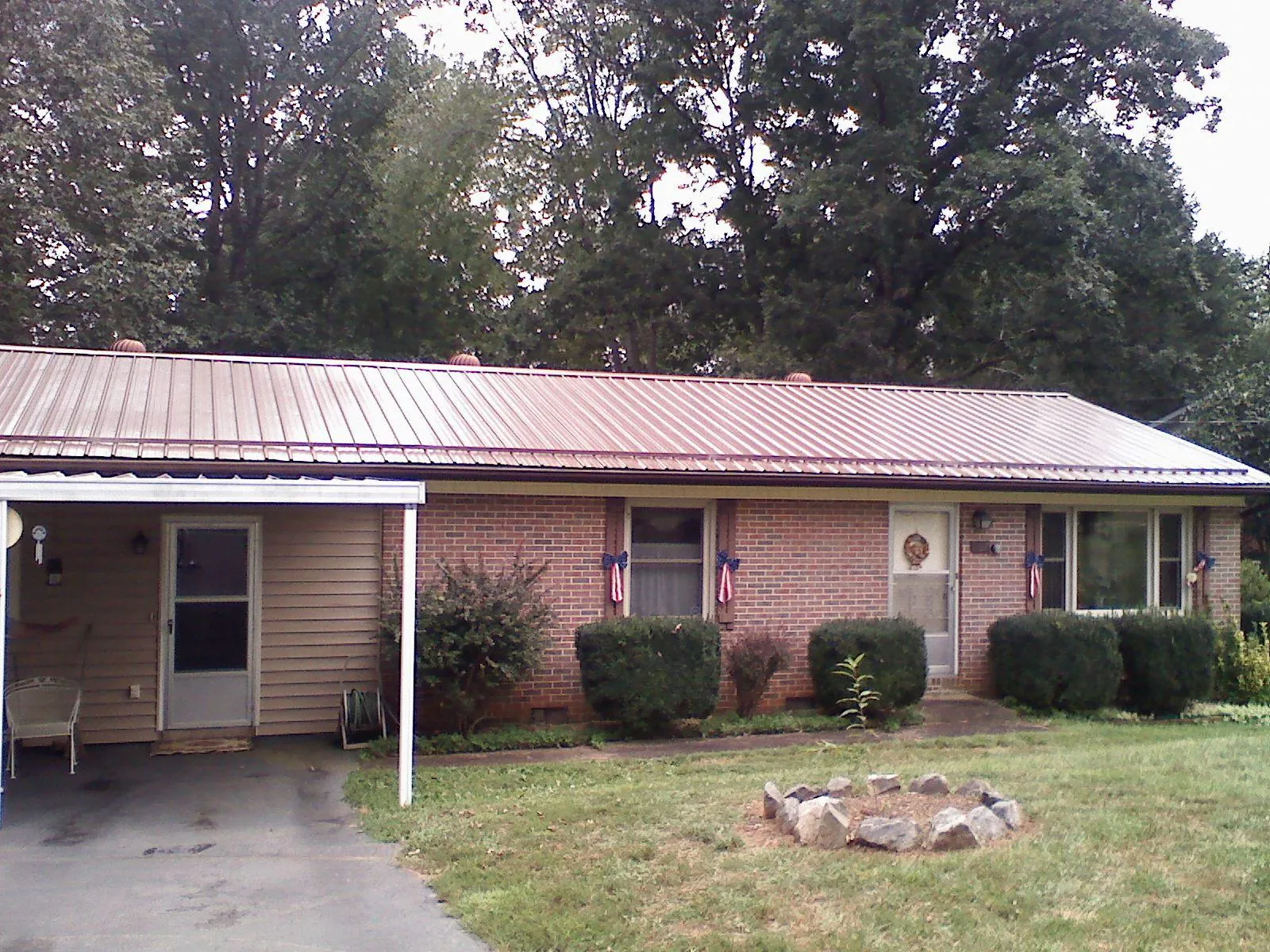 Bronze metal roof and carport on a brick ranch home — Roof Repair work by our crew in Sugar Tree
